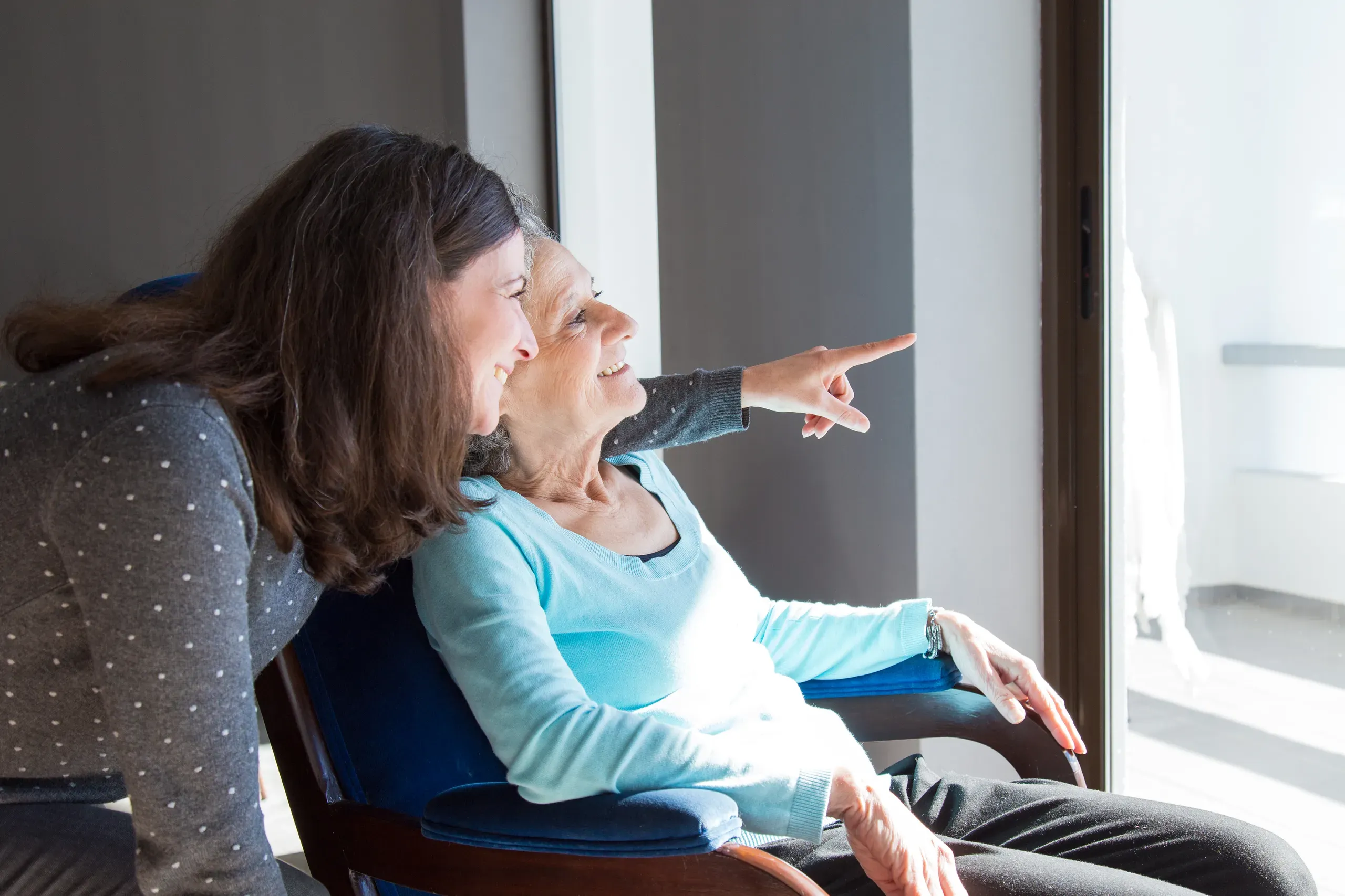 A mother and daughter sharing a peaceful moment with a scenic view.